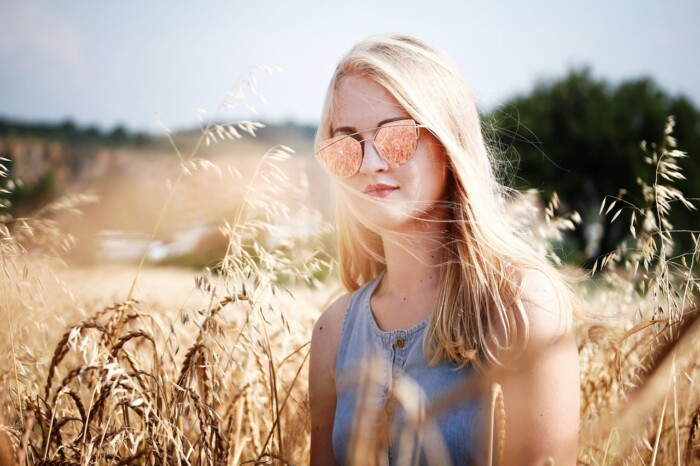 vrouw met zonnebril in hooiveld