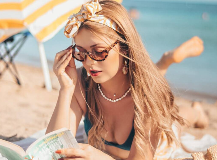 vrouw onder parasol aan het lezen