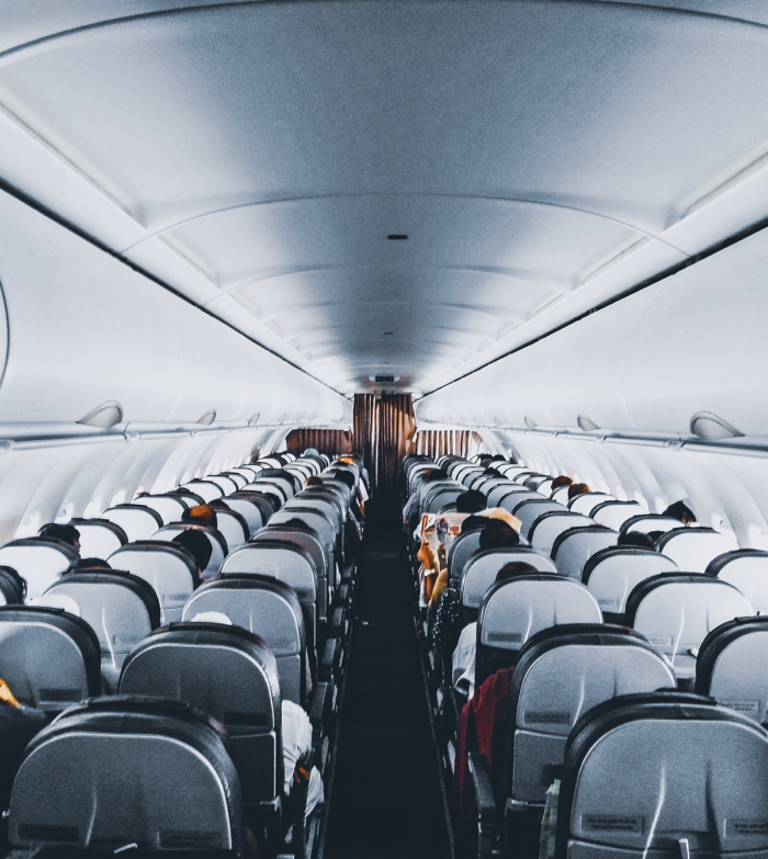 cabine van een vliegtuig met stoelen en passagiers