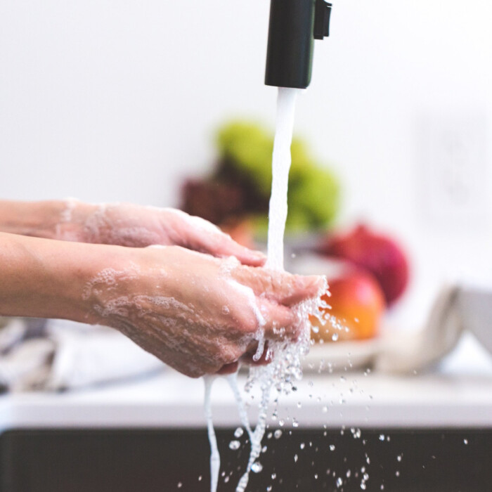 handen wassen onder een lopende kraan