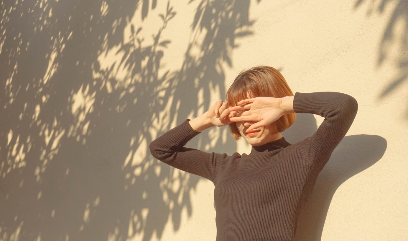 vrouw in zon die haar ogen bedekt