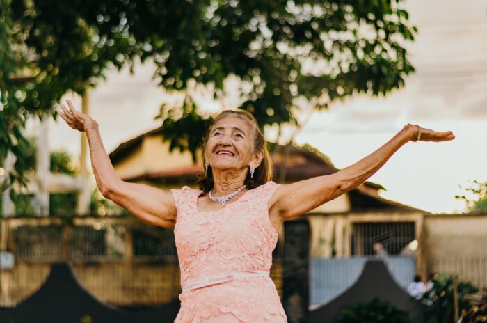 Blije oude vrouw met haar armen in de lucht