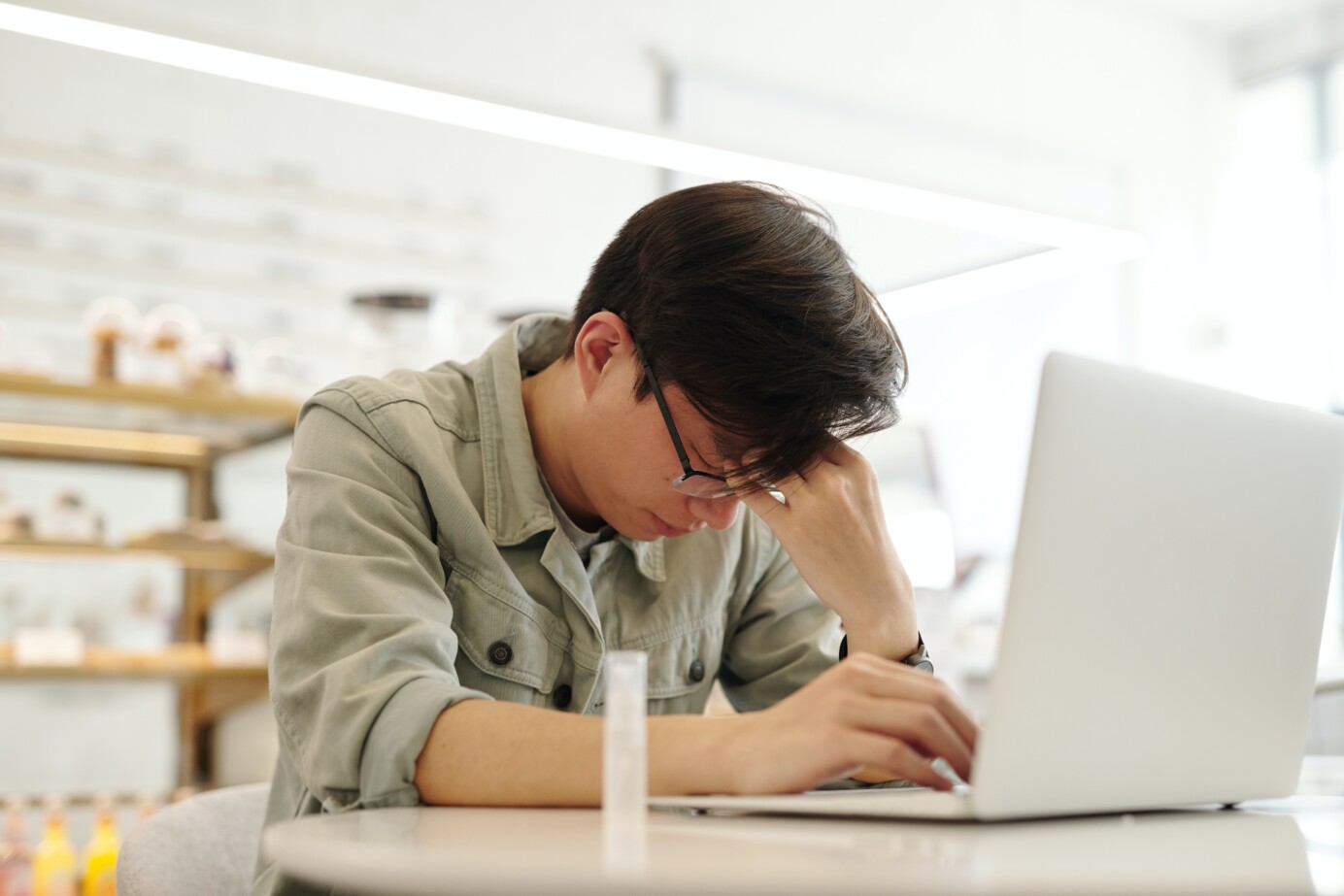 Man met oogmigraine achter laptop