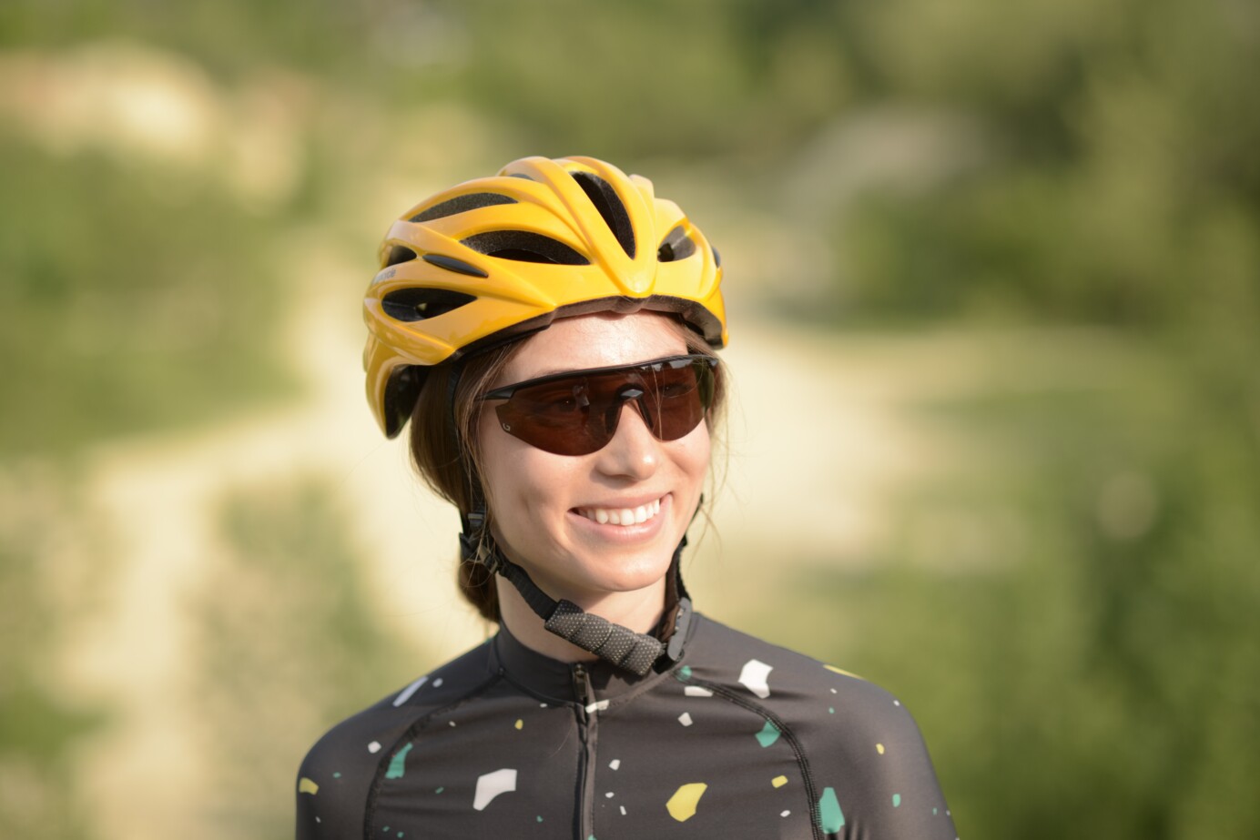 Portret van vrouw in wielrenkleding met bril en helm