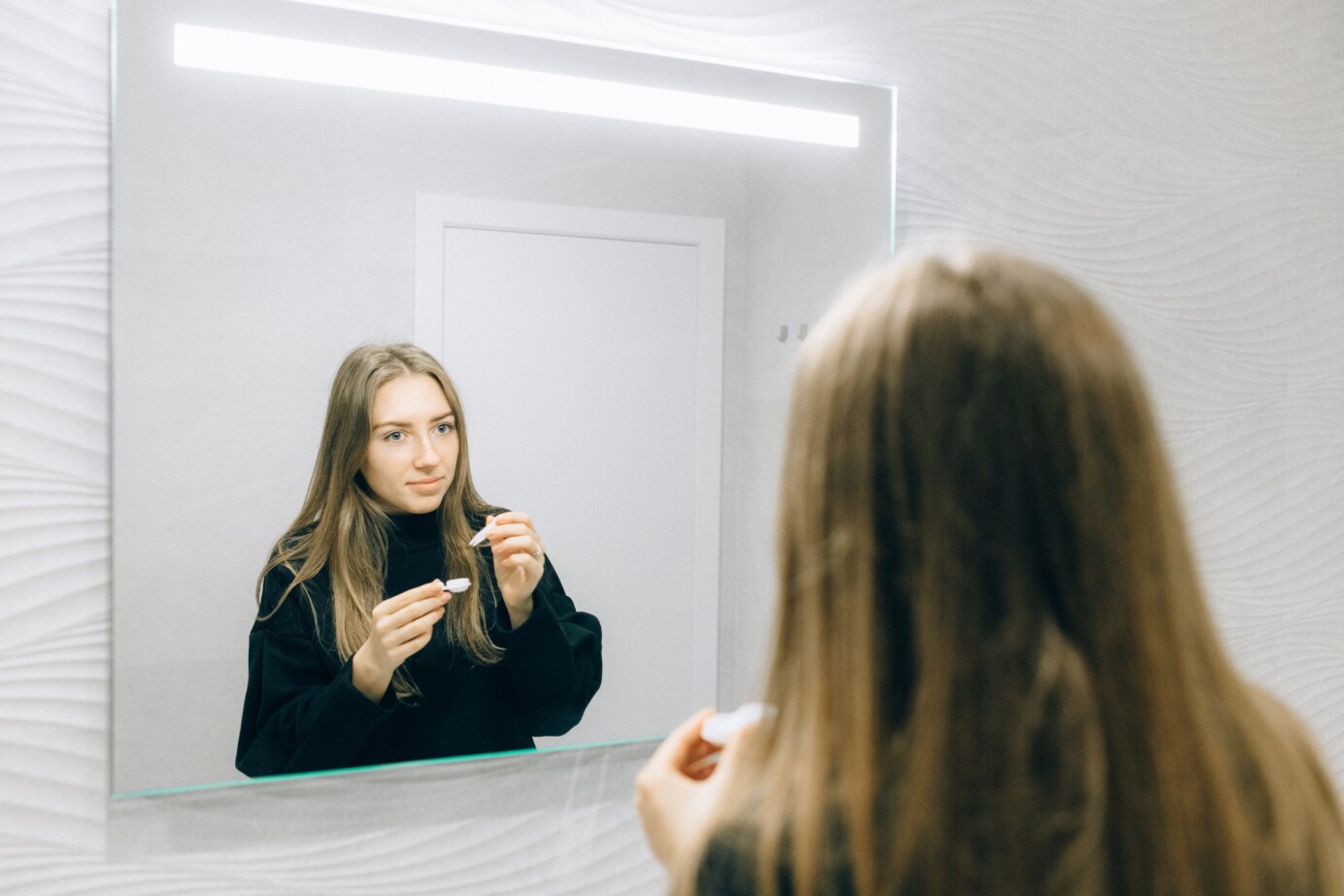 Vrouw haalt lens uit contactlensvloeistof