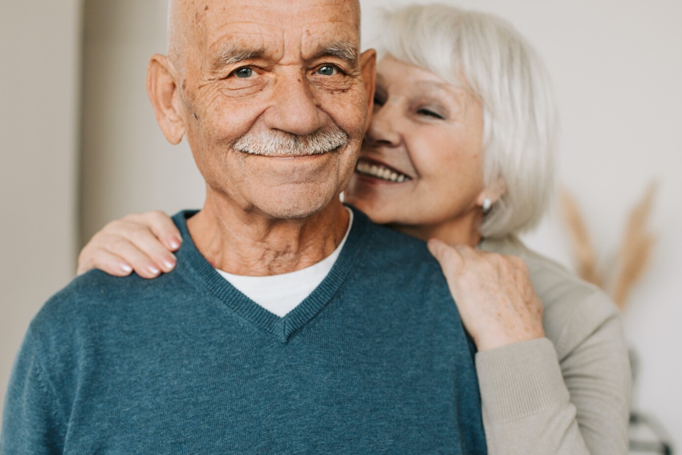 Een ouder stel (man en vrouw) kijkt gelukkig in de camera