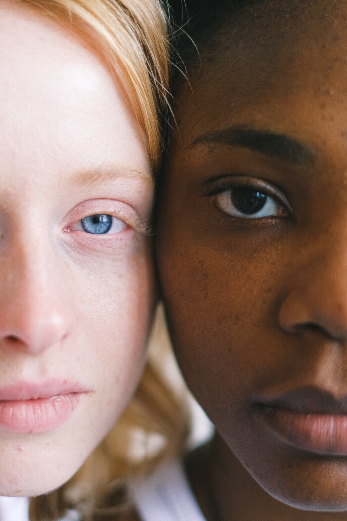 Foto van een wit meisje met blauwe ogen en een zwart meisje met bruine ogen